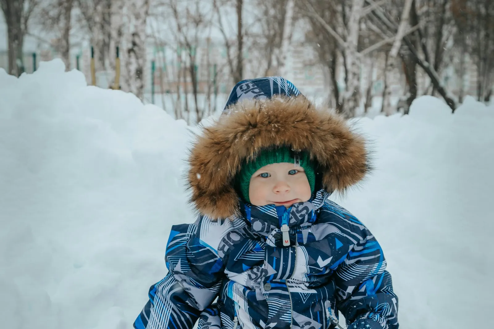 A small child in a snowsuit and fur-trimmed hood